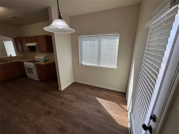 a view of a kitchen with a sink dishwasher wooden floor and a window