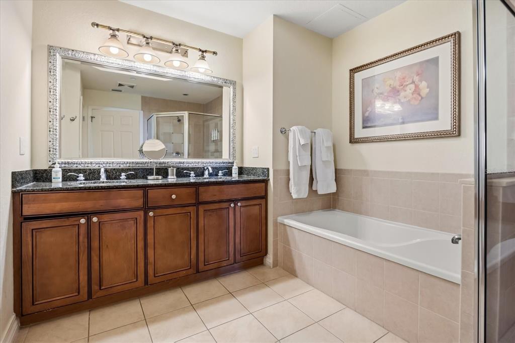 1114 Sunset View Circle, Unit 402 Reunion, FL 34747 - Photo 8 of 32 a bathroom with a granite countertop sink a toilet a mirror and bathtub