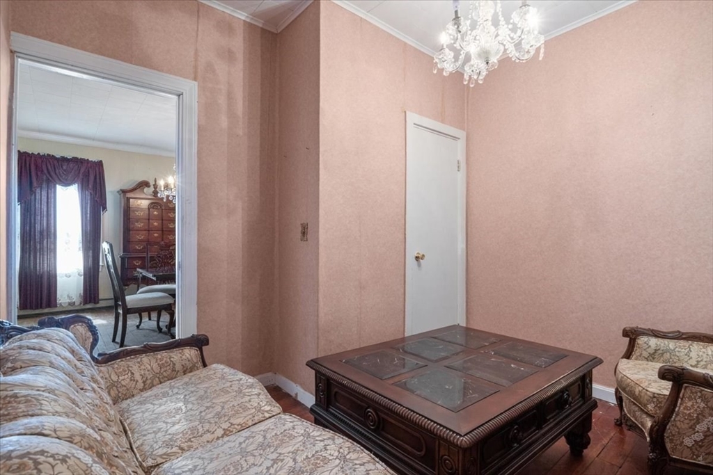 128 Diman Street Fall River, MA 02721 - Photo 11 of 42 a living room with a bed and a chandelier