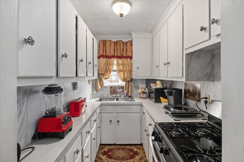128 Diman Street Fall River, MA 02721 - Photo 18 of 42 a kitchen with a white stove top oven and cabinets