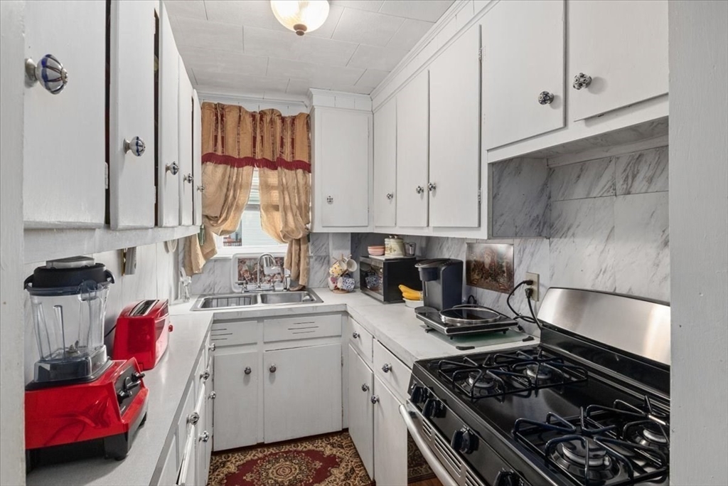 128 Diman Street Fall River, MA 02721 - Photo 19 of 42 a kitchen with a stove a sink and cabinets