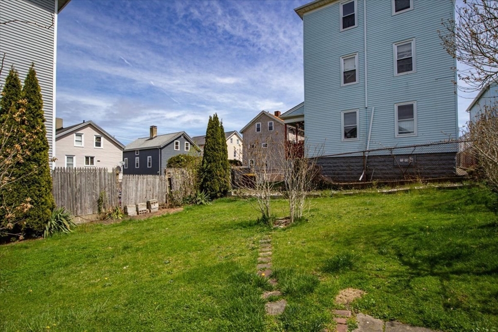 128 Diman Street Fall River, MA 02721 - Photo 39 of 42 a backyard of a house with plants and wooden fence
