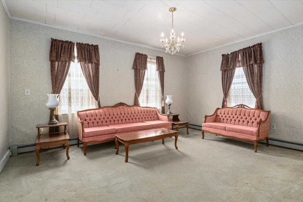 128 Diman Street Fall River, MA 02721 - Photo 6 of 42 a bedroom with a bed and a chandelier
