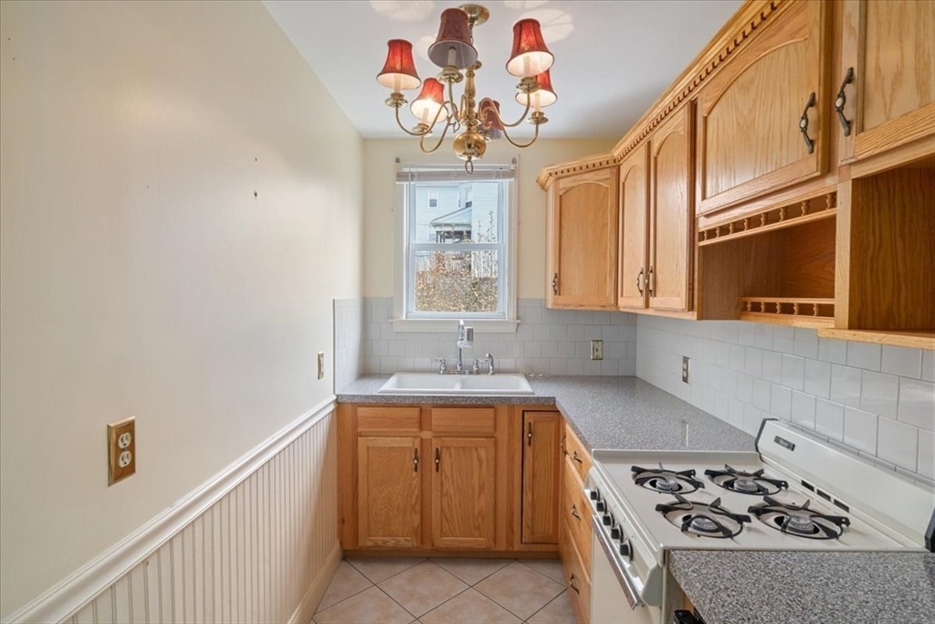 128 Diman Street Fall River, MA 02721 - Photo 10 of 42 a kitchen with a stove a sink and a microwave