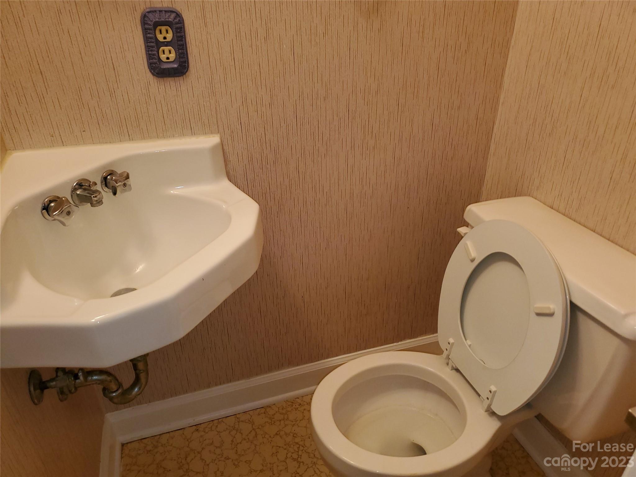 6100 Pleasant Grove Road Charlotte, NC 28216 - Photo 11 of 14 a bathroom with a sink a toilet and a mirror