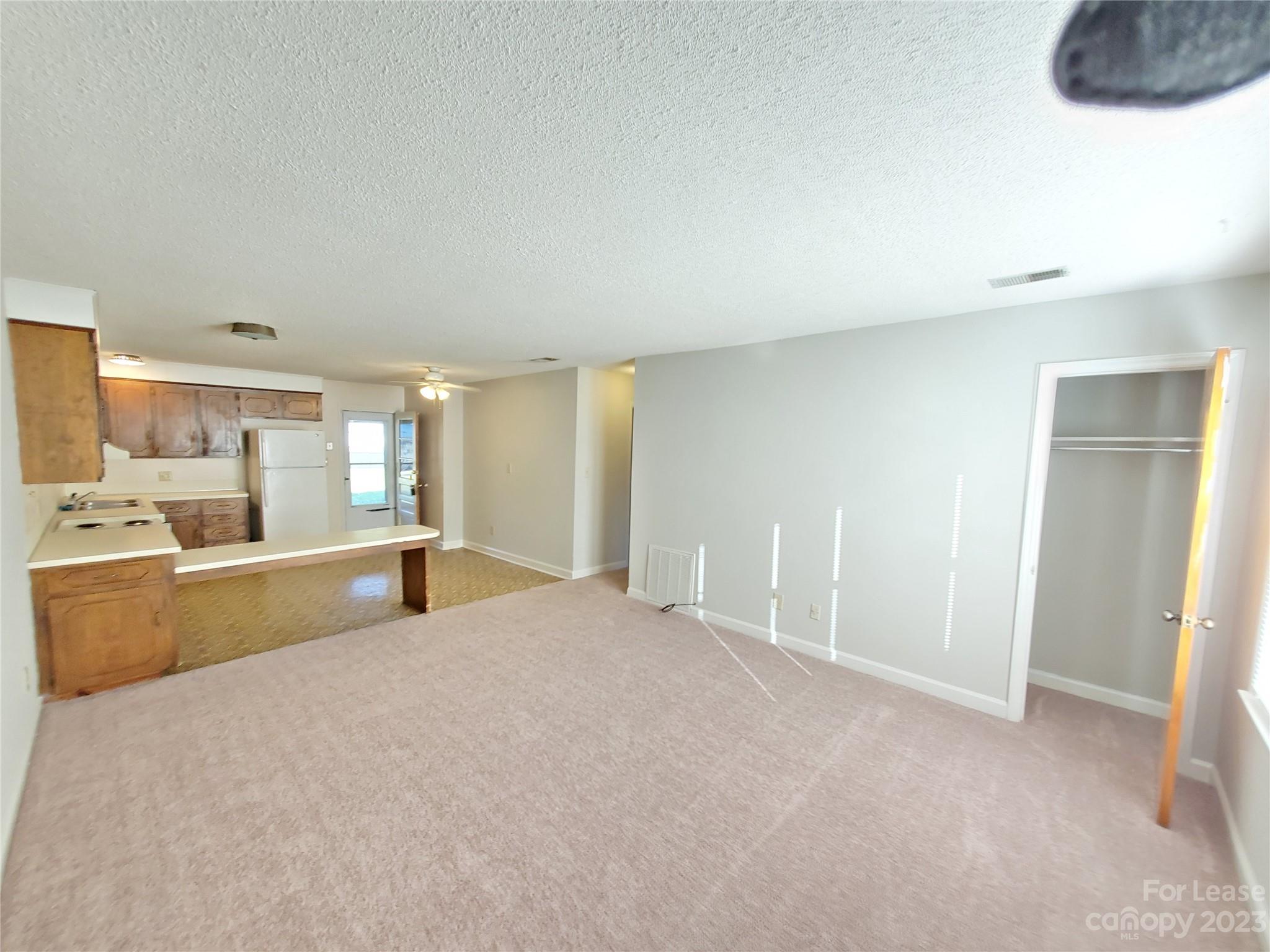 6100 Pleasant Grove Road Charlotte, NC 28216 - Photo 2 of 14 a large bedroom with a large bed and a view of kitchen