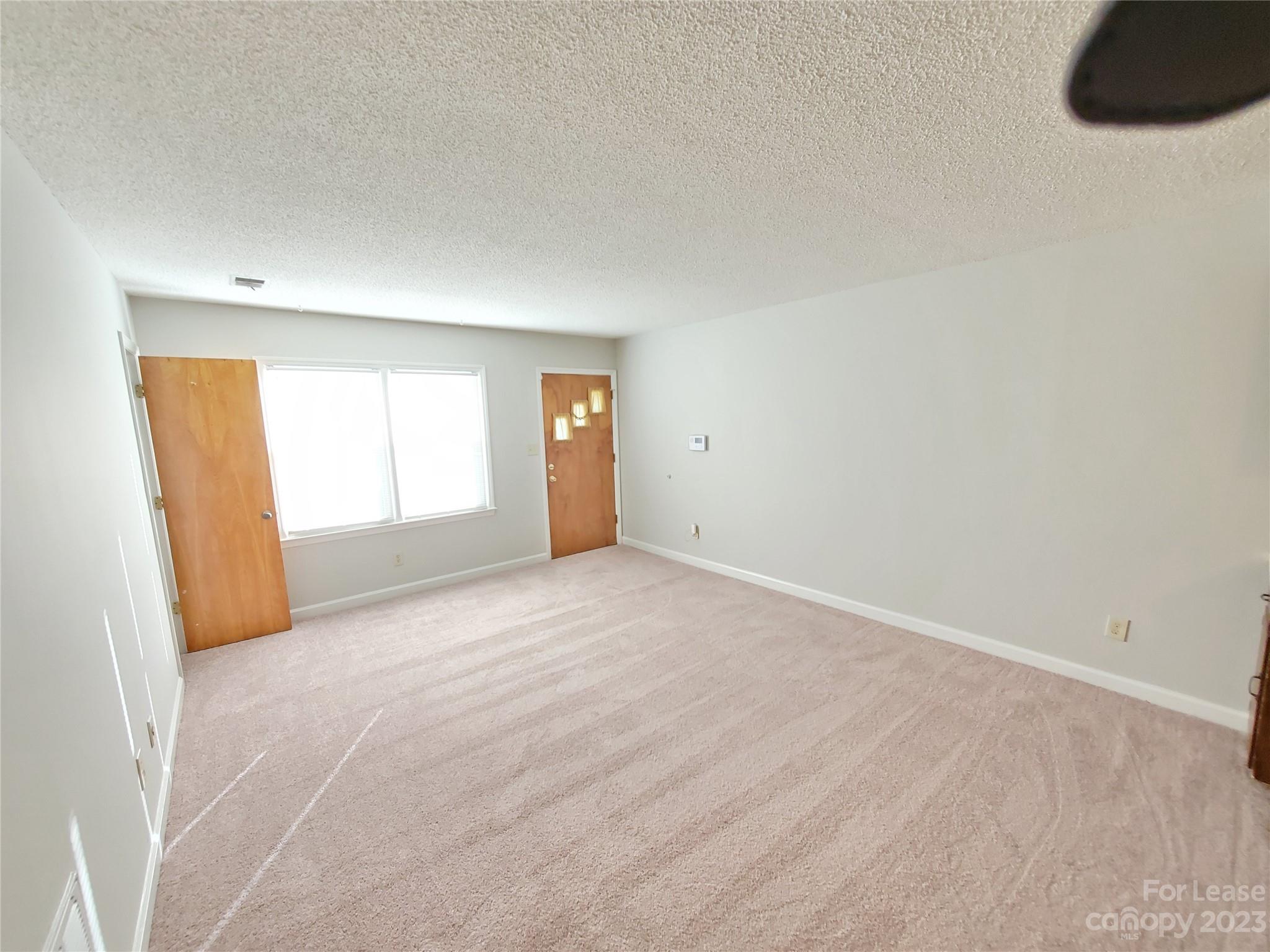6100 Pleasant Grove Road Charlotte, NC 28216 - Photo 3 of 14 an empty room with windows