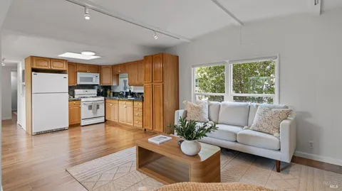 a living room with furniture wooden floor and a large window