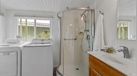 a bathroom with a granite countertop sink a mirror and a shower