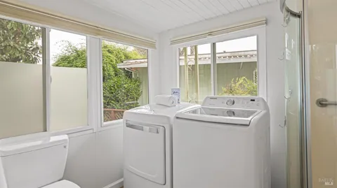 a bathroom with a sink toilet and large window