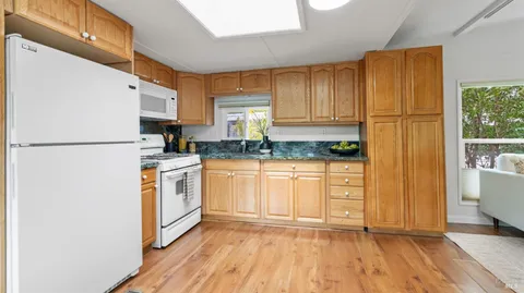 a kitchen with a refrigerator a stove top oven and cabinets