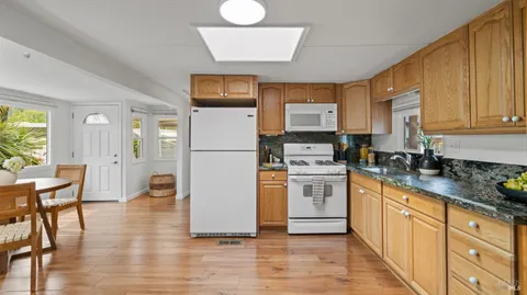 a kitchen with a refrigerator a stove a sink cabinets and a dining table