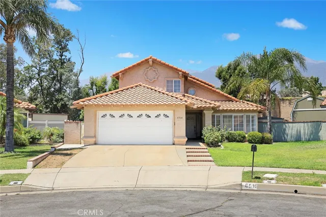 a front view of a house with a garden and plants