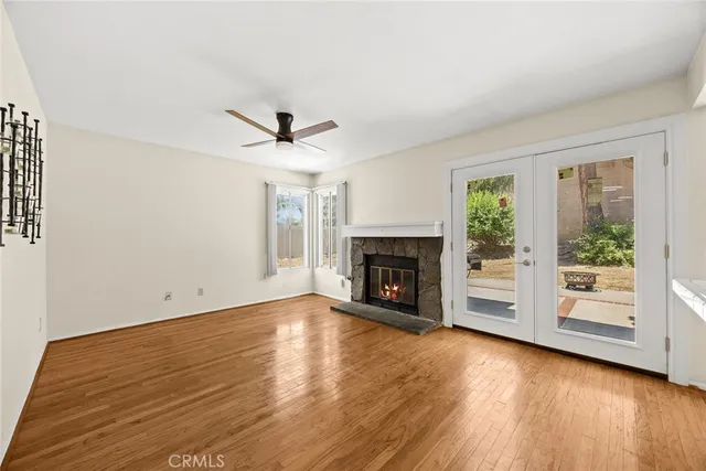 an empty room with windows fireplace and wooden floor