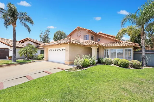 a view of a house with a yard and potted plants