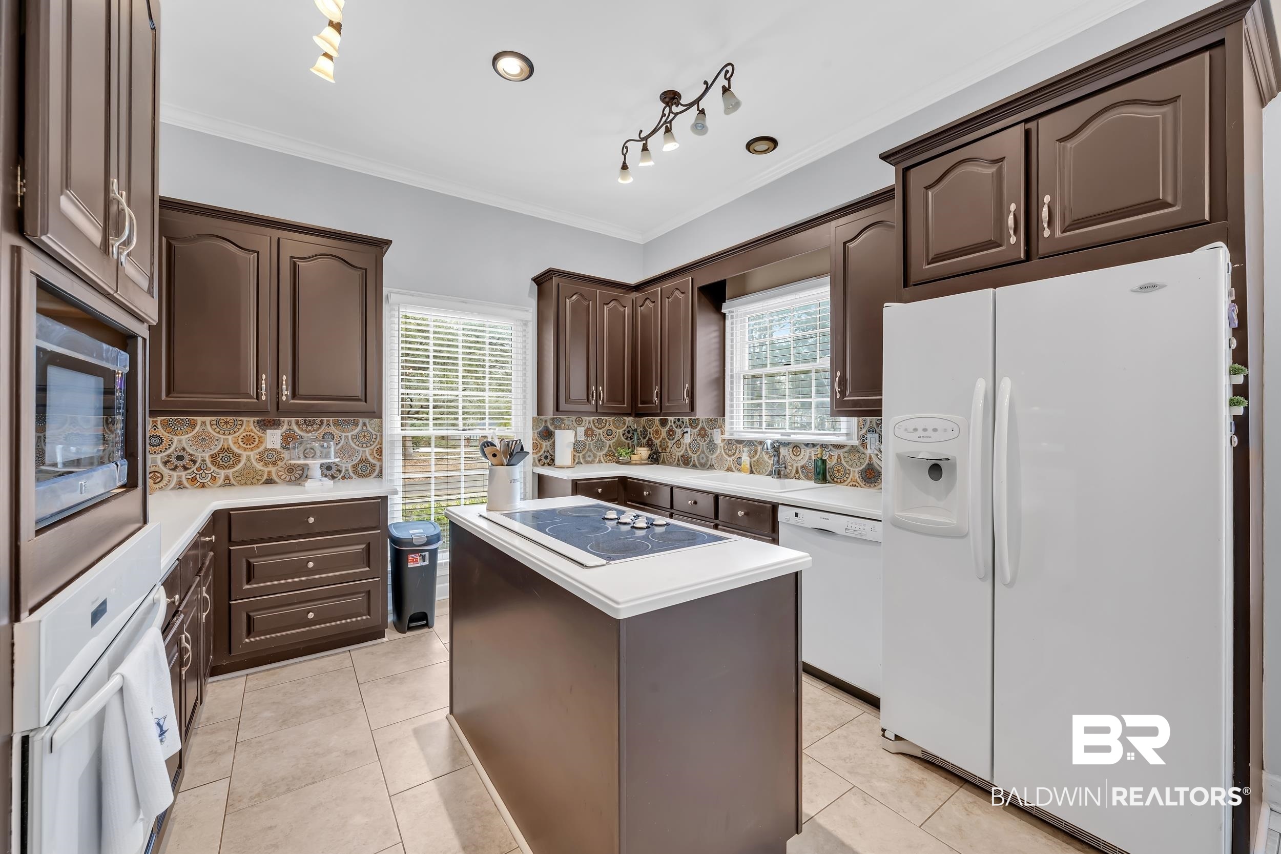 2858 Postoak Circle Mobile, AL 36693 - Photo 18 of 32 Kitchen featuring white appliances, crown molding, dark brown cabinets, light countertops, and a kitchen island