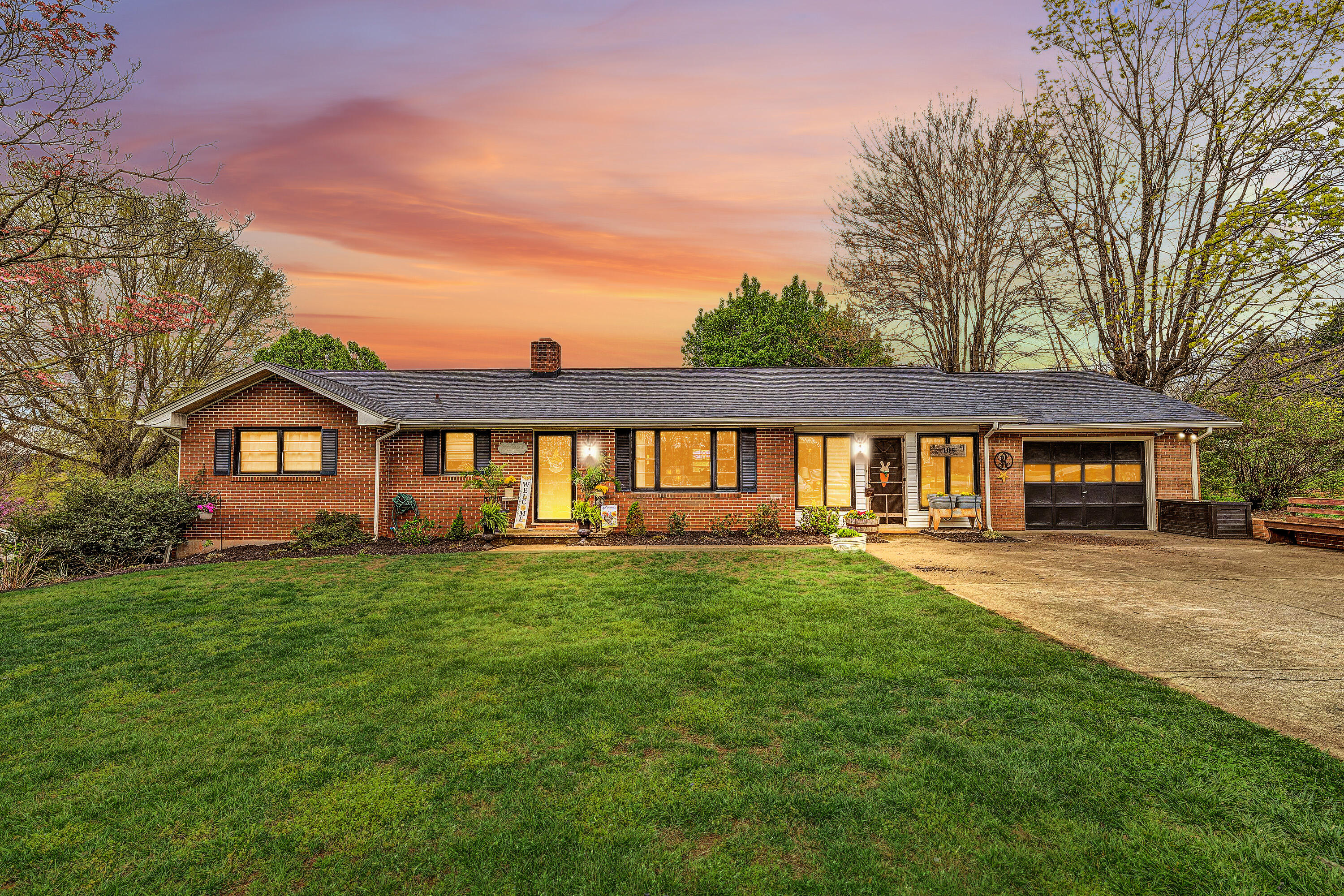 a front view of a house with yard and green space