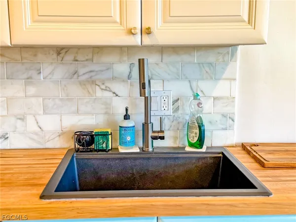 a close view of a sink a mirror and cabinets
