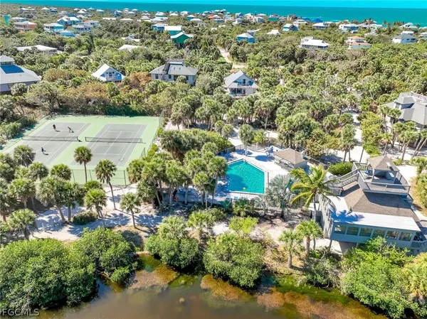 an aerial view of residential houses with outdoor space and trees