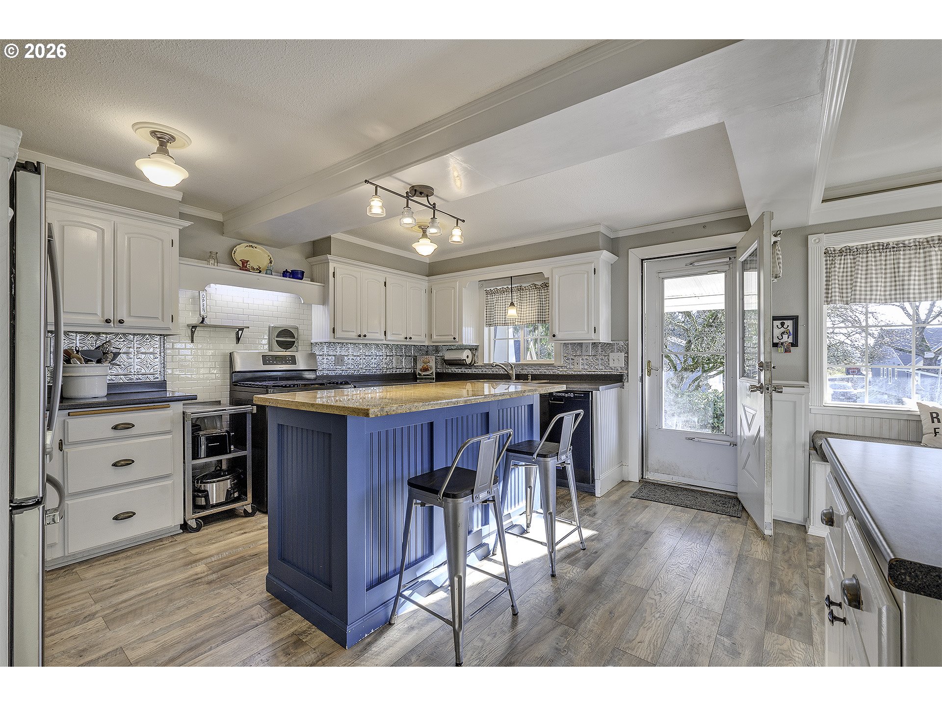 58059 Shadley Lane Warren, OR 97053 - Photo 7 of 39 a kitchen with kitchen island granite countertop a refrigerator a stove a dining table and chairs with wooden floor