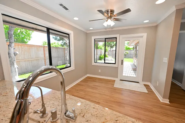 a large kitchen with cabinets wooden floor and stainless steel appliances
