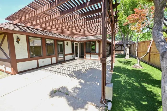 a backyard of a house with table and chairs