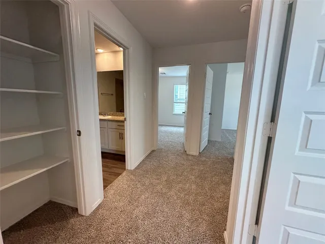 a view of a hallway with wooden shelves