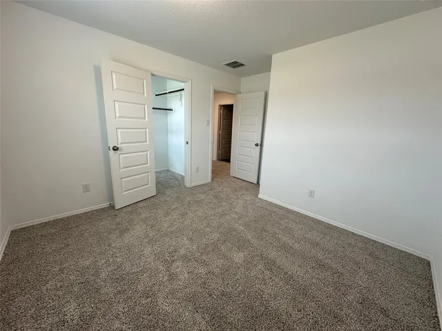 an empty room with closet and mirrors