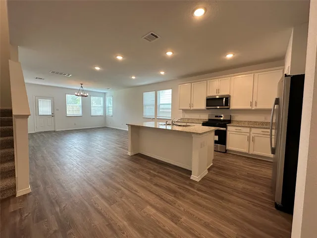 a kitchen with stainless steel appliances a refrigerator sink and microwave