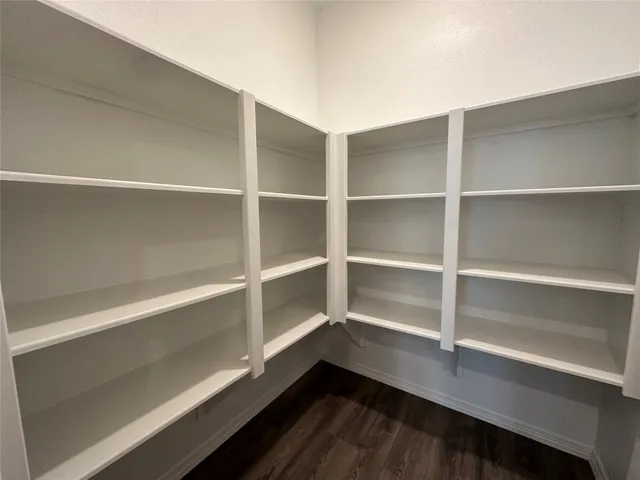 a view of walk in closet with empty racks