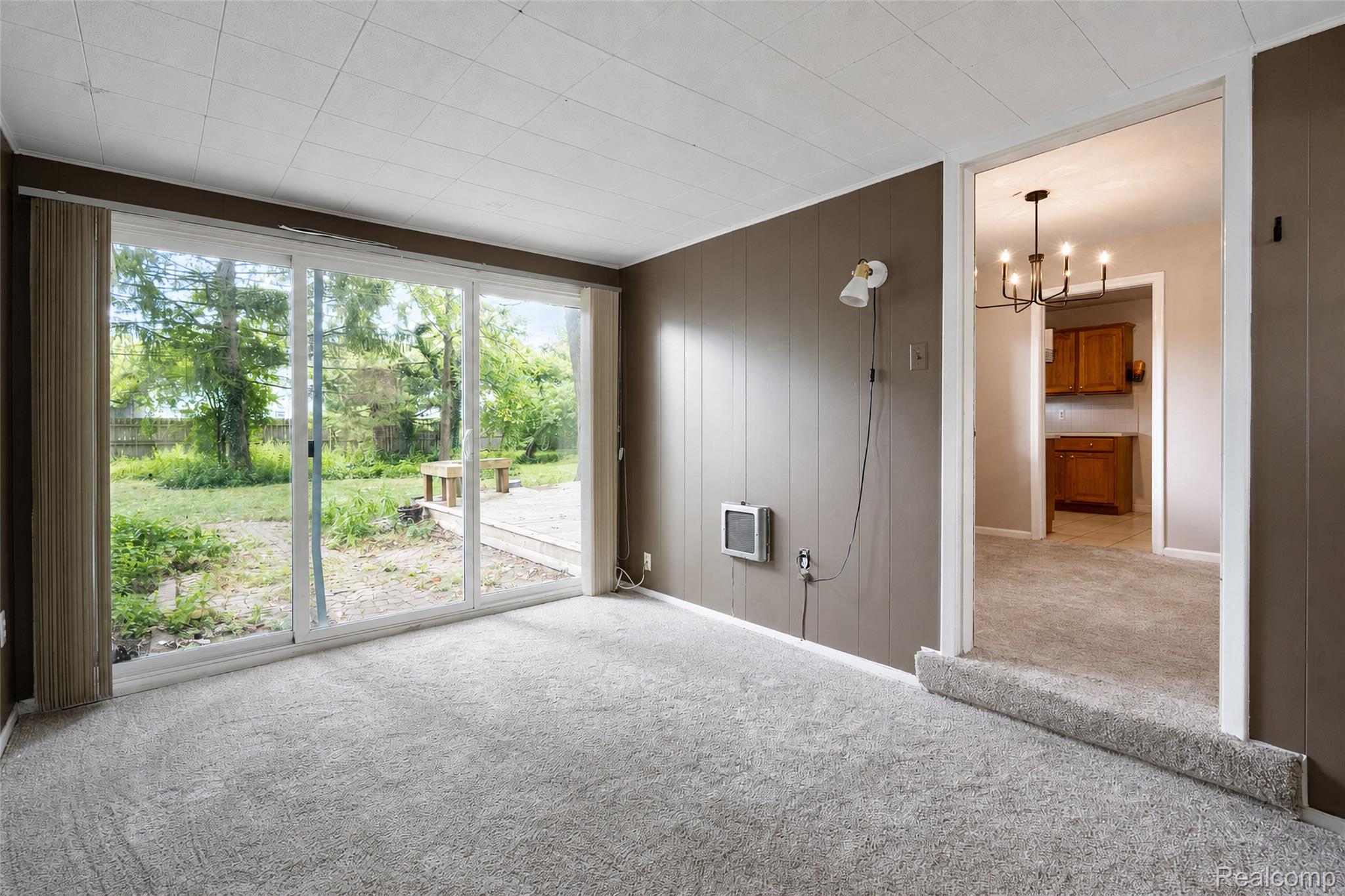 1846 Pembroke Road Birmingham, MI 48009 - Photo 17 of 37 Sliding glass doors, textured paneling, wall-mounted heater, recessed ceiling, and a built-in light fixture