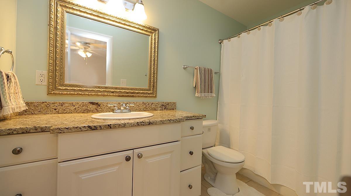 2208 Stafford Avenue, Unit 202 Raleigh, NC 27607 - Photo 10 of 15 a bathroom with a granite countertop sink toilet and a mirror