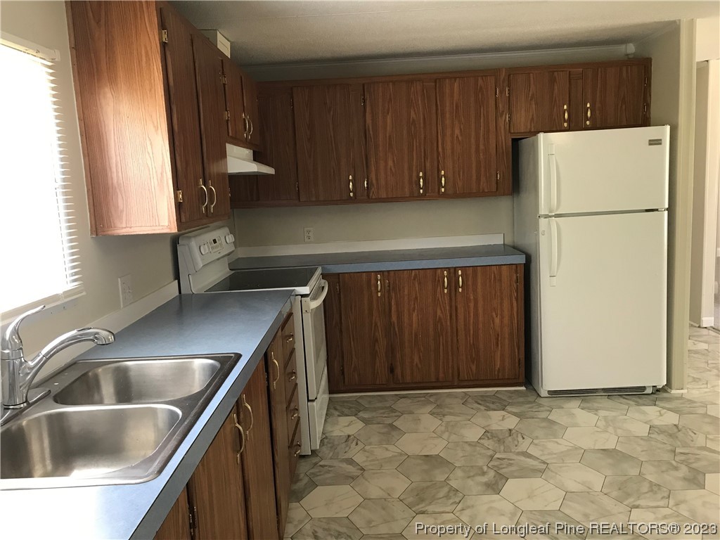 2046 Wade-Stedman Road Stedman, NC 28391 - Photo 11 of 17 a kitchen with a refrigerator sink and cabinets