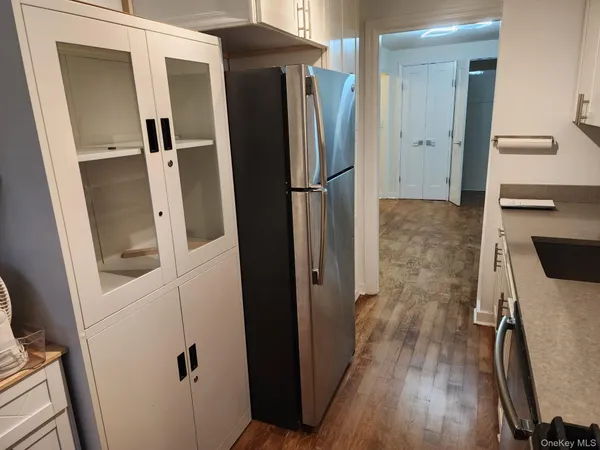 a kitchen with a refrigerator and wooden floor