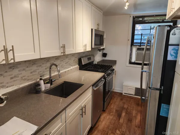a kitchen that has a sink cabinets counter space and stainless steel appliances