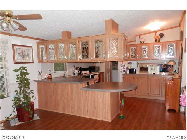 3415 Wickham Road Bumpass, VA 23024 - Photo 4 of 12 a view of a kitchen with furniture and a potted plant