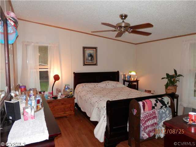 3415 Wickham Road Bumpass, VA 23024 - Photo 6 of 12 a bedroom with a bed and a chandelier