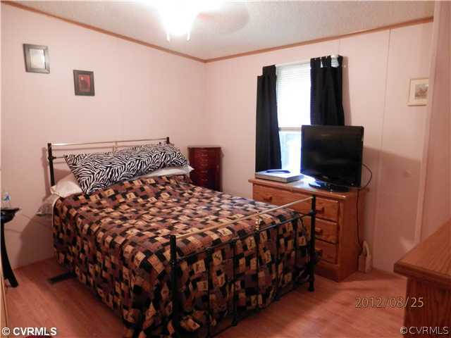 3415 Wickham Road Bumpass, VA 23024 - Photo 7 of 12 a bedroom with a bed and tv
