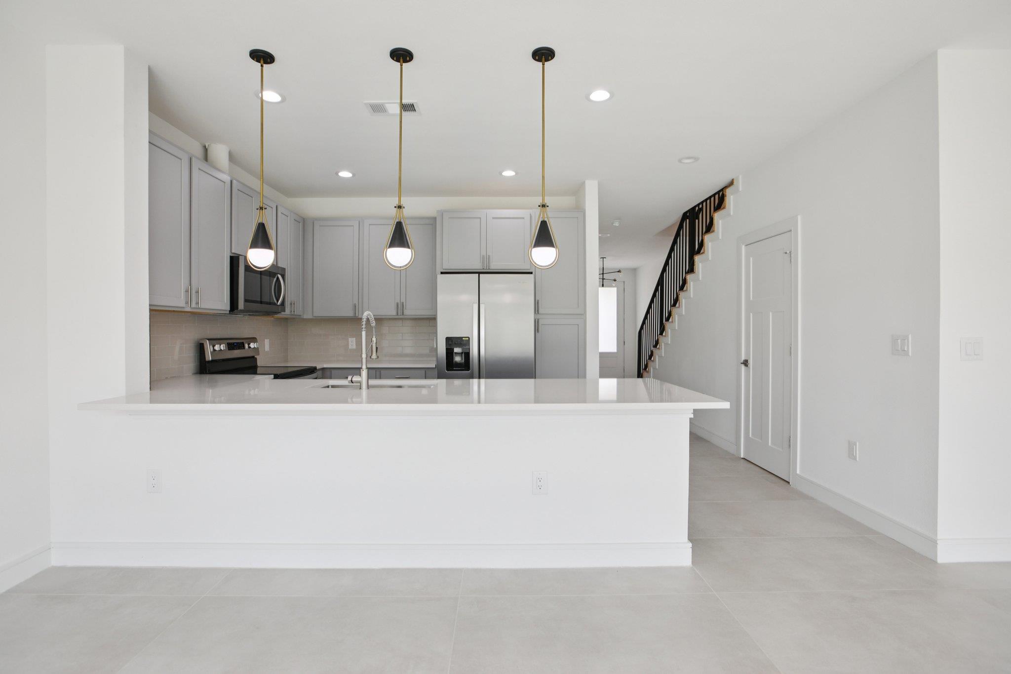 302 Tesla Circle Austin, TX 78681 - Photo 11 of 40 a large kitchen with stainless steel appliances kitchen island a large island a sink a stove and a window