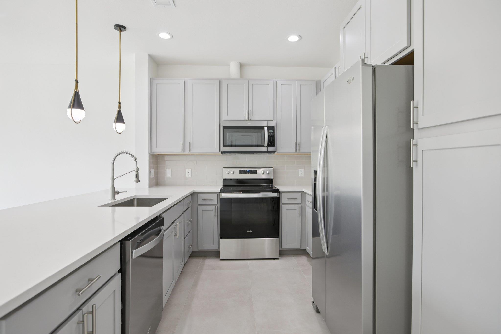 302 Tesla Circle Austin, TX 78681 - Photo 13 of 40 a kitchen with stainless steel appliances granite countertop a refrigerator and a stove top oven