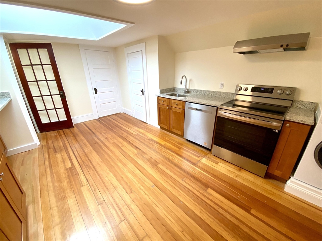 24 Clyde Road, Unit 3 Watertown, MA 02472 - Photo 2 of 13 a kitchen with a sink appliances wooden floor and a window