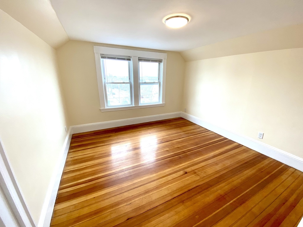 24 Clyde Road, Unit 3 Watertown, MA 02472 - Photo 6 of 13 a view of an empty room with wooden floor and a window