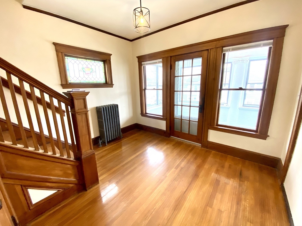 24 Clyde Road, Unit 3 Watertown, MA 02472 - Photo 9 of 13 a view of an empty room with wooden floor and windows