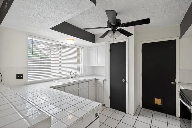 a kitchen with stainless steel appliances kitchen island granite countertop a refrigerator and a sink