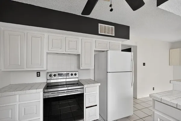 a kitchen with a stove refrigerator and cabinets