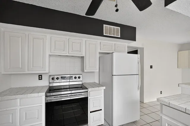 a kitchen with a stove refrigerator and cabinets