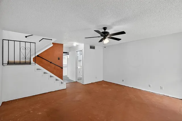 a view of a livingroom with a ceiling fan and stairs