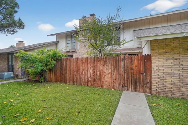 a view of a house with a yard and a large tree