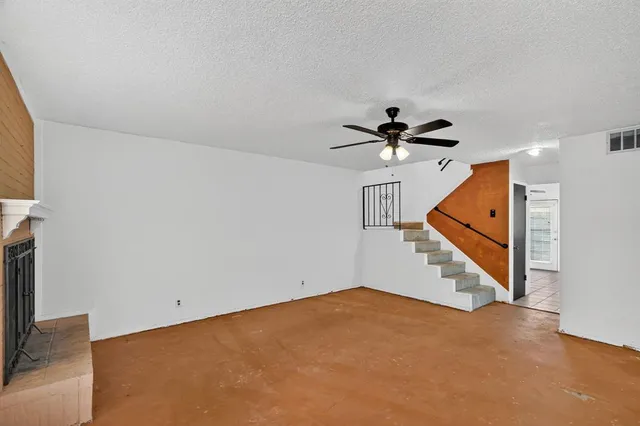 an empty room with a ceiling fan and window