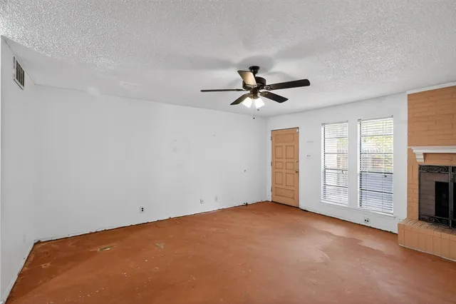 a view of an empty room with a fireplace and a window